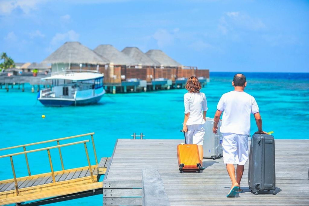 Casal chegando com bagagens nas Ilhas Maldivas depois de horas de vôo